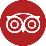 Red circle with white abstract owl logo, symbolizing TripAdvisor, featuring stylized owl eyes and beak.
